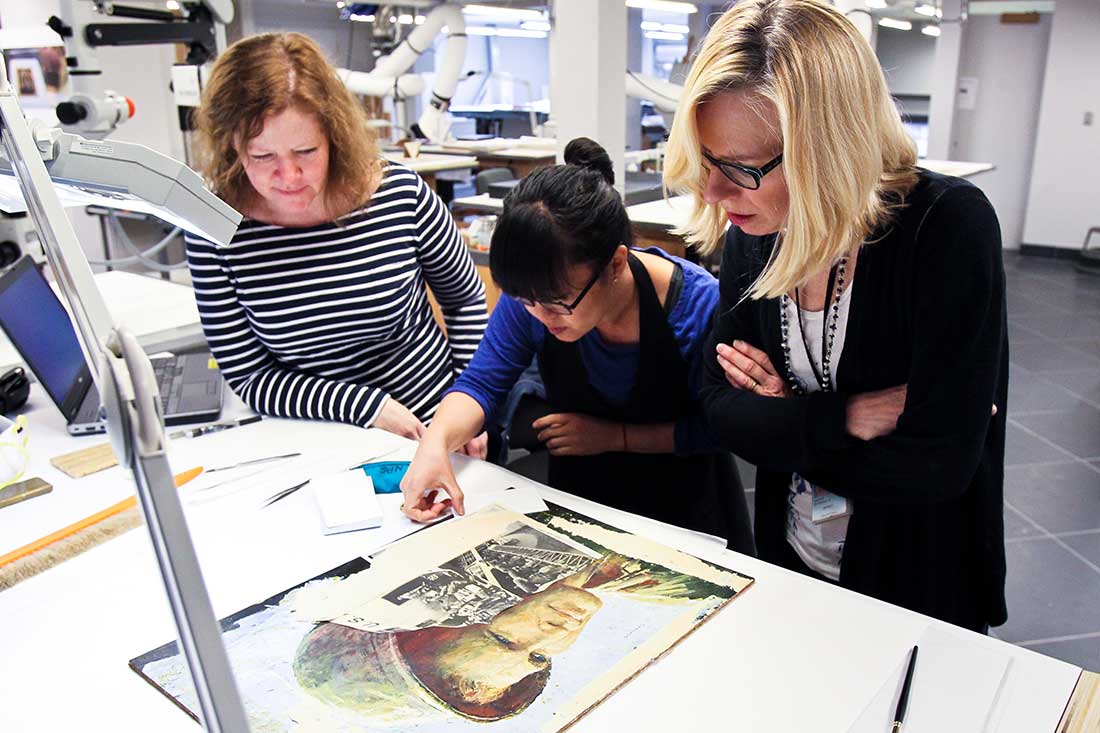 Two conservators examinging a portrait