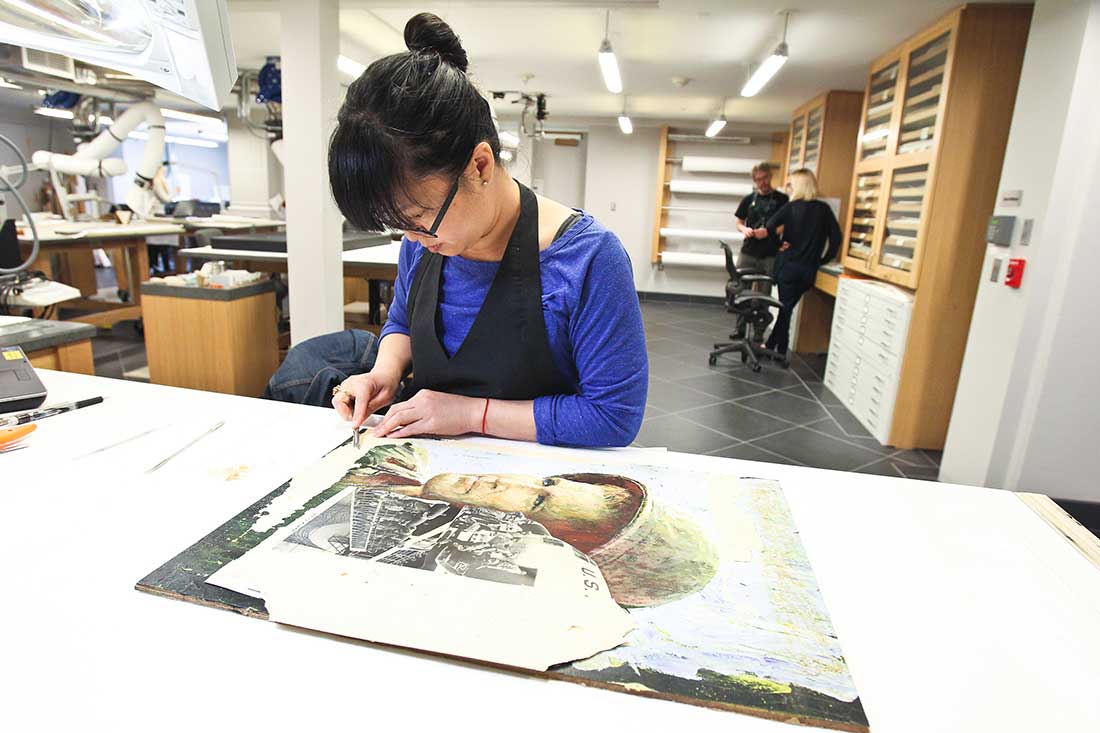 Cponservator removing tape from a work of art